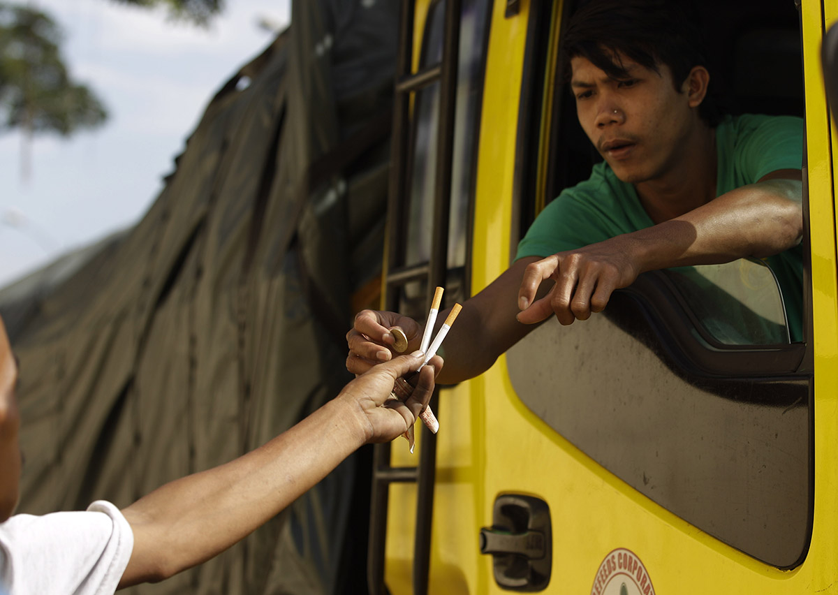 Ένας άνδραας αγοράζει τσιγάρα στη Μανίλα, στις Φιλιππίνες, μετά την έγκριση επιβολής φόρων σε καπνό και αλκοόλ.